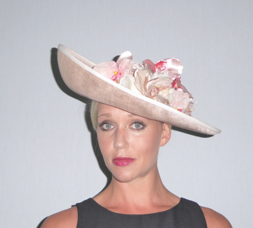 A beautiful up turned brim  & round shallow crown in Peachy Sinamay makes this hat one of my favorites.  Edged in Ivory with a mixture of Pink/ Peach Orchid type flowers.