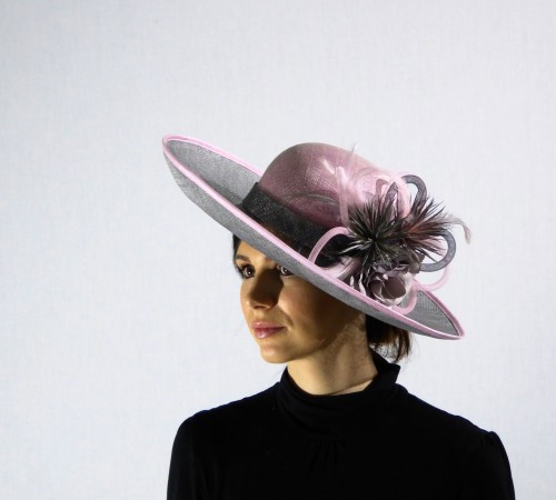 This hat has a round crown and turned up brim  shown in Pink & Grey Sinamay, decorated with pink & grey feathers and grey loops. 