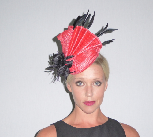 Button style fascinator in Coral Parasisal fabric with black adornments.