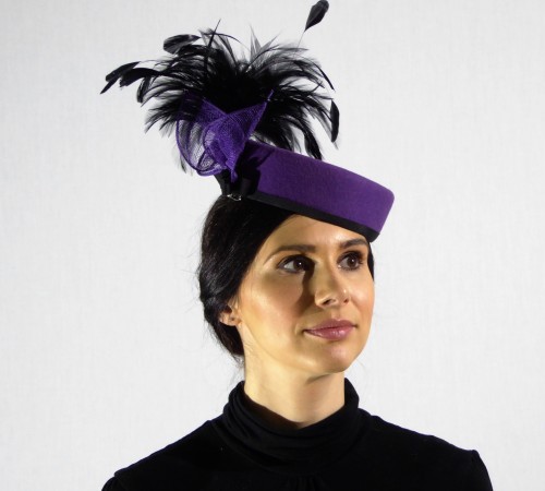 Pill box style in purple felt and large black feathers.