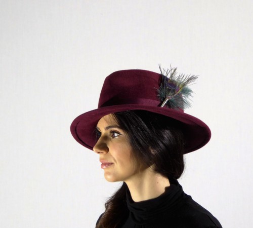 Velour fedora in wine decorated with peacock eye feather and wine headband.